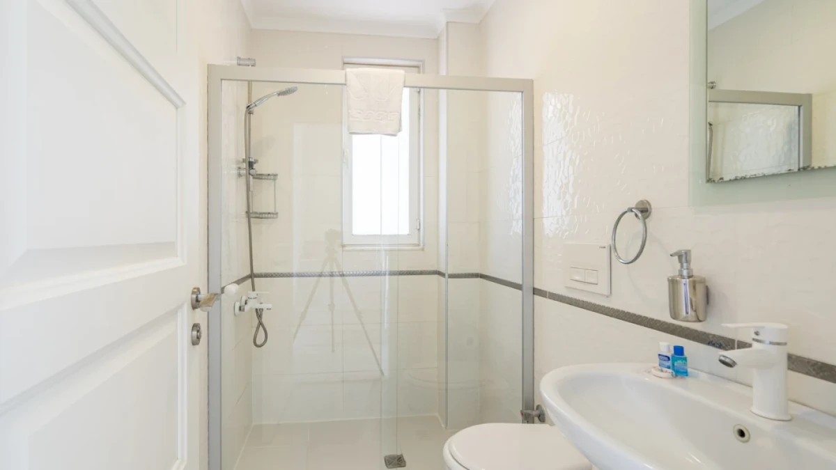 Bright and simple bathroom with glass shower cabin