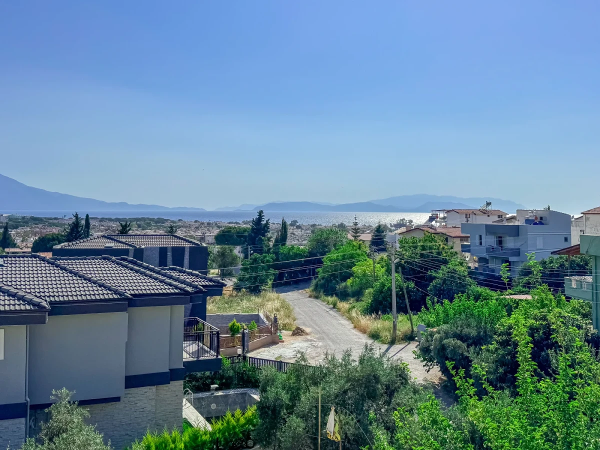 Kuşadası Villa Elma havuz alanı – şezlonglar ve çim bahçe ile havuz kenarı