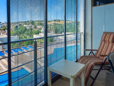 Balkon oturma alanı, havuz manzarası ve cam kaplama