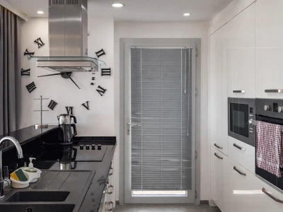 Modern mutfak, ankastre cihazlar ve kapıya açılan camlı alan