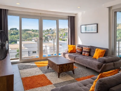 Geniş oturma odası, balkon ve manzaralı büyük cam kapılar